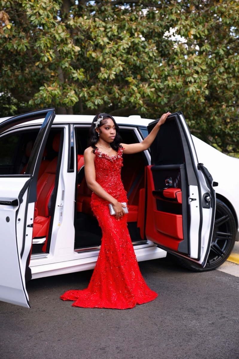 Woman in a red gown stepping out of a car