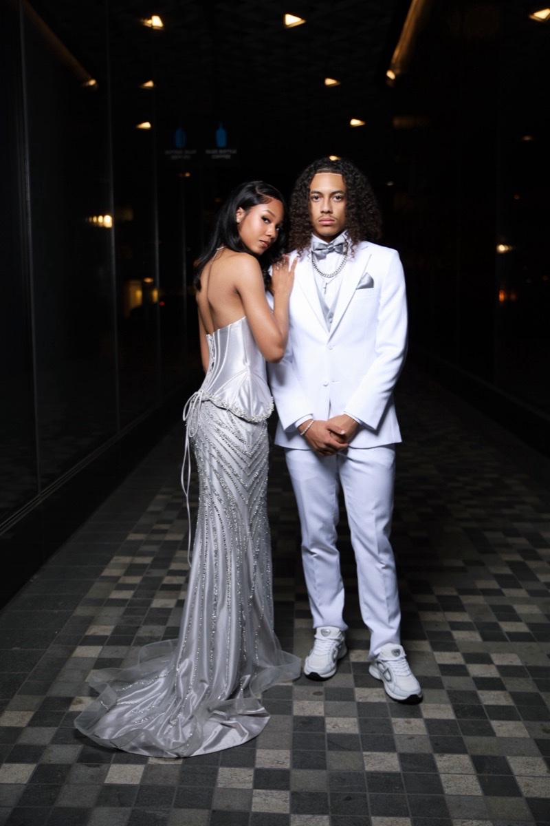 Prom couple in silver and white formalwear at night in the city