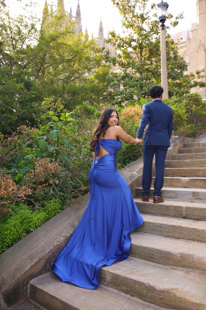 Couple in a blue gown and navy suit on a garden staircase