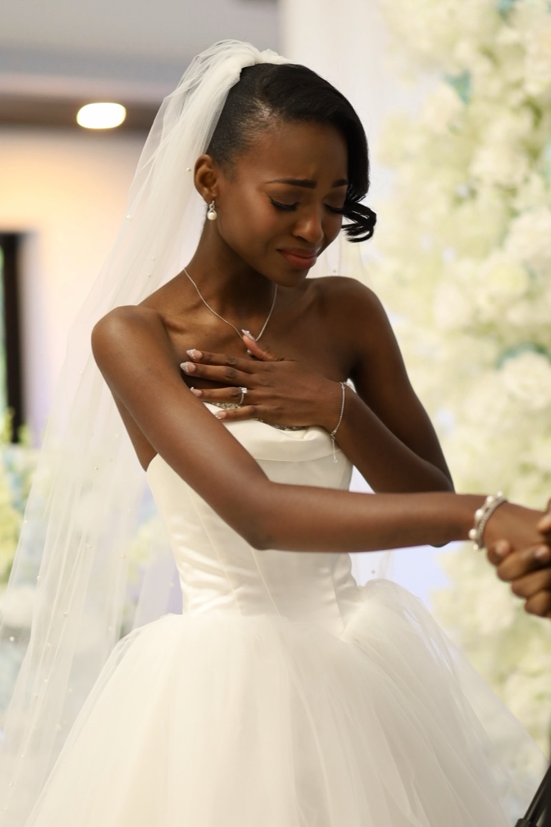Bride in a wedding gown and veil adjusting her sleeve
