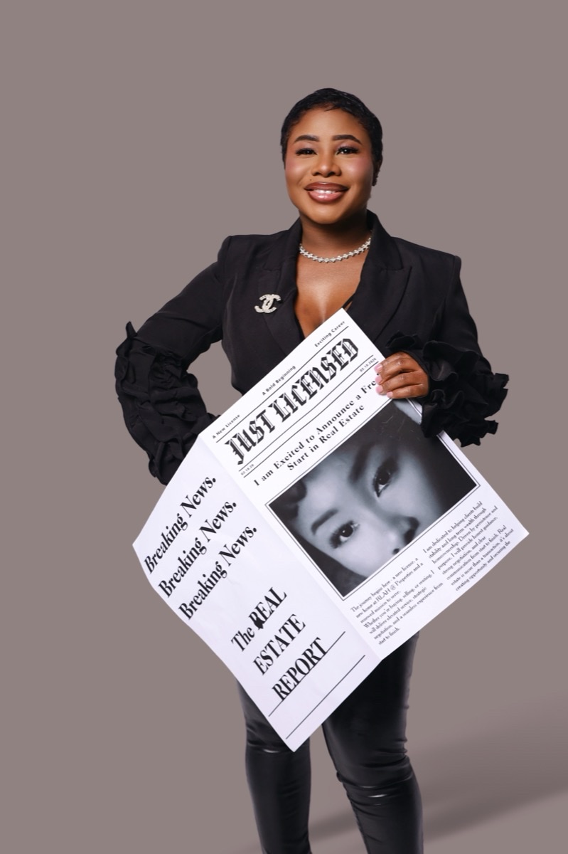 Woman in a blazer holding a real estate feature flyer, studio portrait