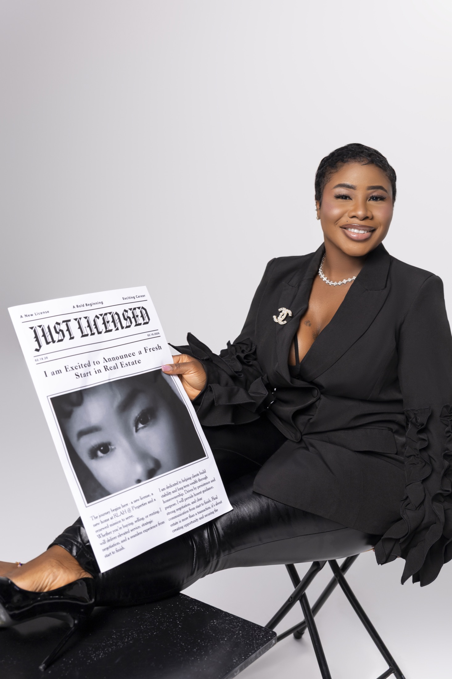 Woman in a black suit holding a Just Licensed feature