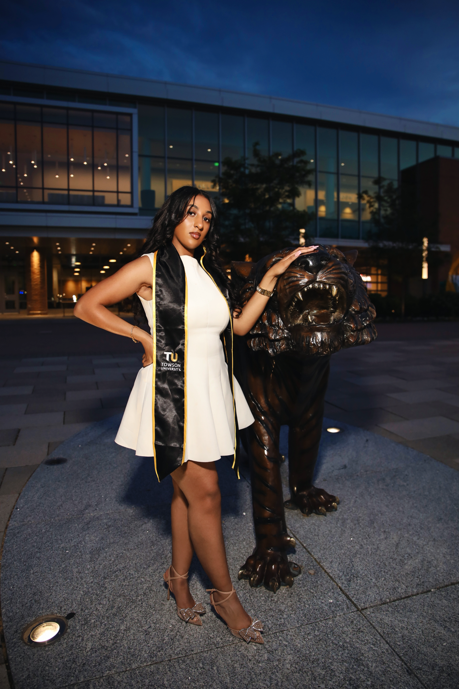 Towson graduate posing beside the tiger statue